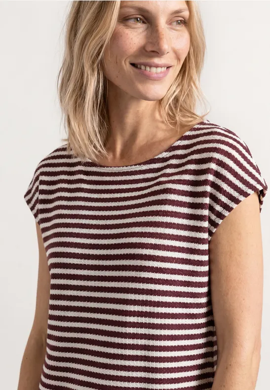 Vrouw met onscherp gezicht draagt een kort mouwtop met witte en bordeaux horizontale strepen.