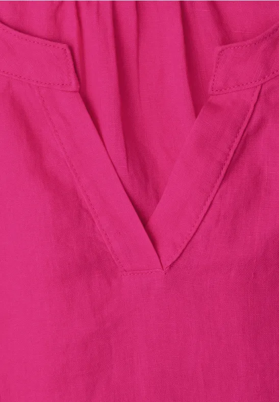 Magenta-farbener Stoff mit V-förmigem Ausschnitt und dezenten Nähten.