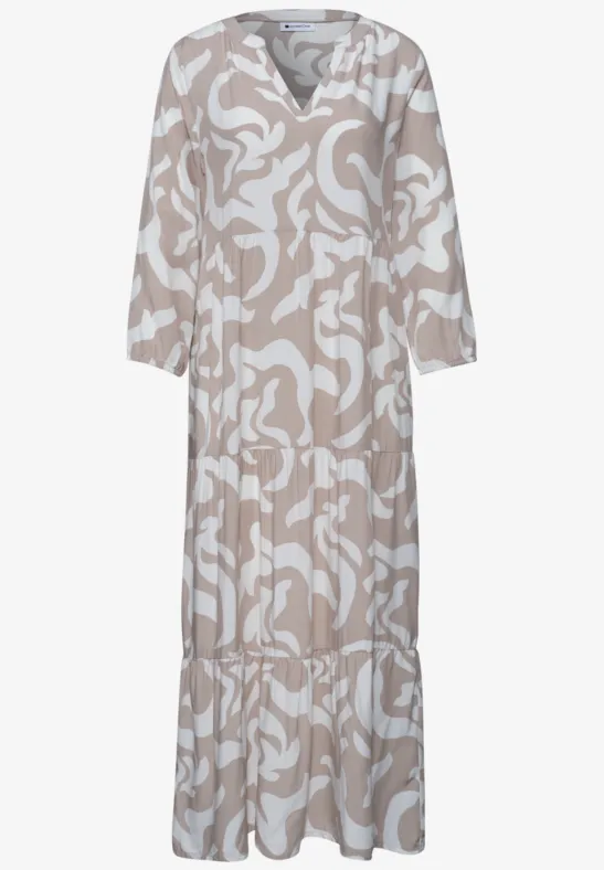 Losvallende maxi-jurk met beige-witte abstracte print, V-hals en lange mouwen.