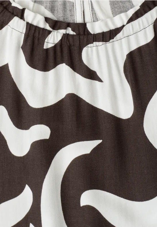 Close-up van kledingstuk met elastische taille en abstracte zwart-witte print.