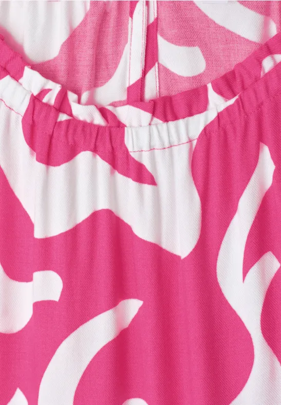 Nahaufnahme eines rosa-weißen Kleidungsstücks mit abstraktem Muster und elastischem Ausschnitt.