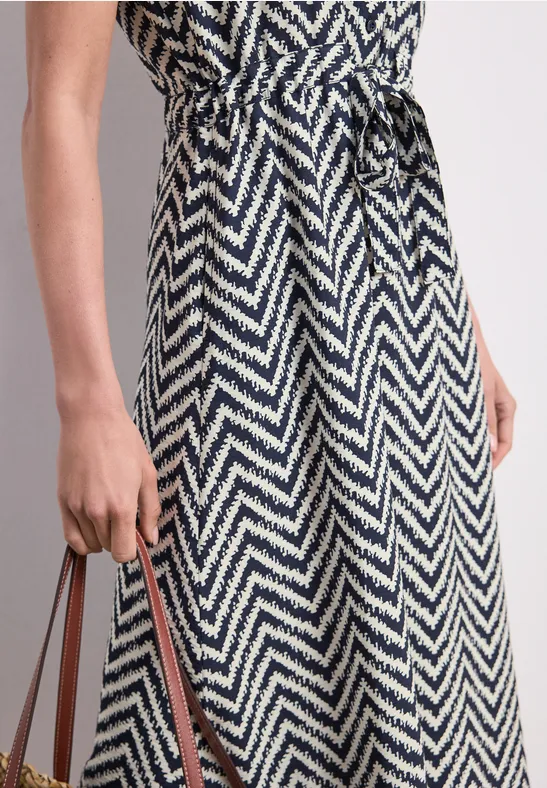 Schwarz-weißes Zickzack-Midikleid mit Taillengürtel, stylisch und elegant.