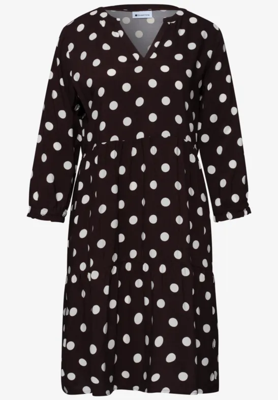 Schwarzes Kleid mit weißen Punkten, V-Ausschnitt und 3/4-Ärmeln.