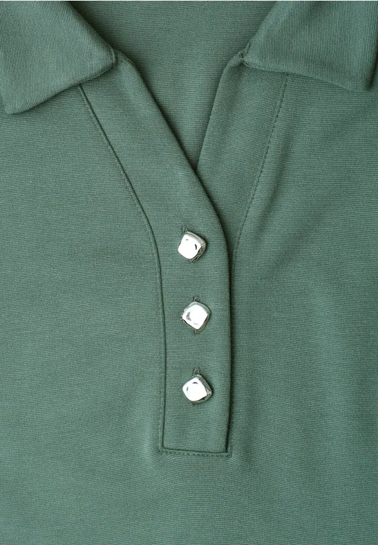 Grünes Poloshirt mit Kragen und drei eckigen weißen Knöpfen.