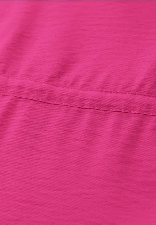 Nahaufnahme eines pinkfarbenen Stoffes mit sichtbarer horizontaler Naht.