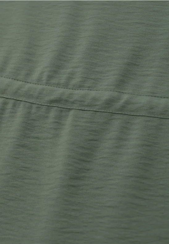 Olivegrüner Stoff mit Naht und leicht sichtbarer Struktur.