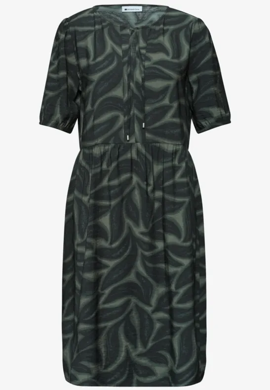 Donkergroene, knielange jurk met abstract bladpatroon en korte mouwen.