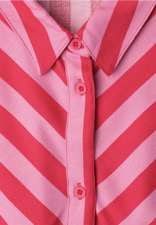 Nahaufnahme eines Hemdes mit rosa und roten diagonalen Streifen und roten Knöpfen.