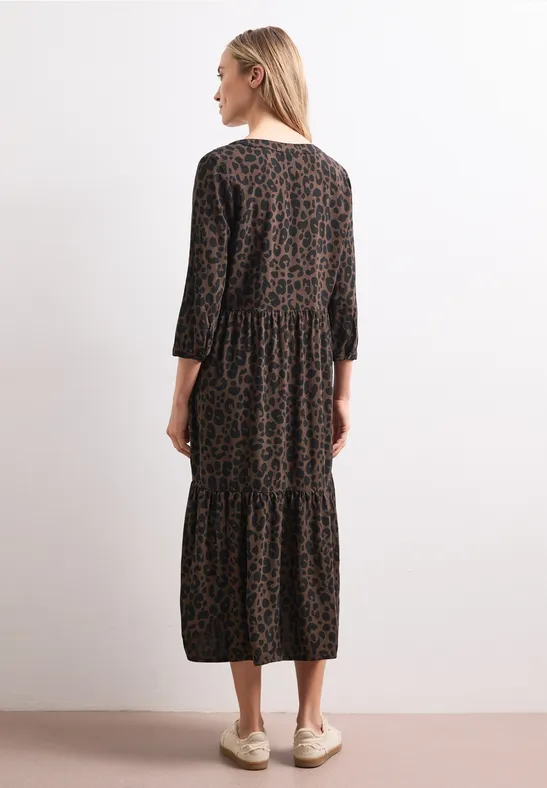Frau in langem, braun-schwarzem Midi-Kleid mit Leoprint und 3/4-Ärmeln, Rückansicht.