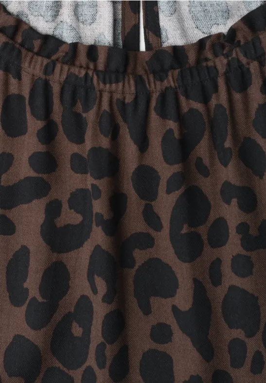 Brauner Stoff mit unregelmäßigen schwarzen Flecken, leicht Leopardenmuster.