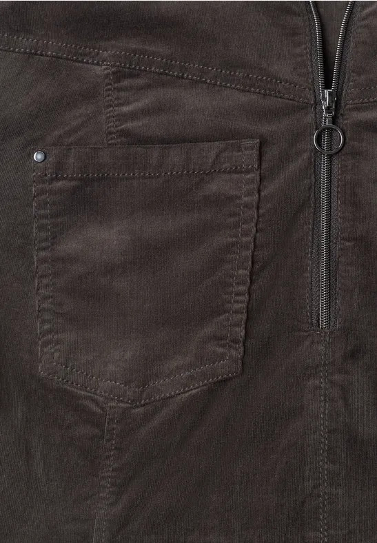 Nahaufnahme einer dunkelbraunen Velourslederjacke mit Reißverschluss und aufgesetzter Tasche.
