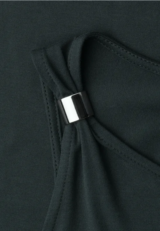 Gros plan sur un vêtement noir avec une boucle métallique argentée sur une lanière.