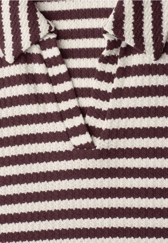 Nahaufnahme eines grob gestrickten Poloshirts in Bordeauxrot und Weiß mit Kragen und V-Ausschnitt.
