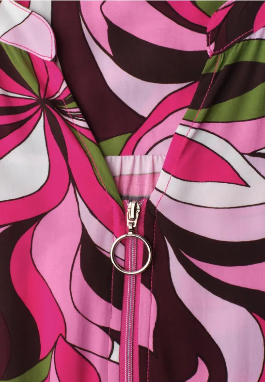 Nahaufnahme eines Reißverschlusses an pink-schwarz-weißen, psychedelischen Stoffmuster.