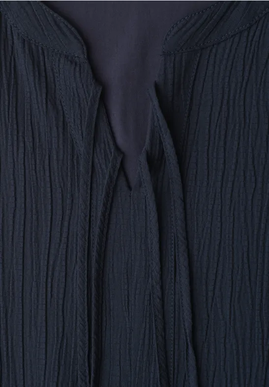 Donkerblauwe, gestructureerde gebreide cardigan met striksluiting bij de hals.