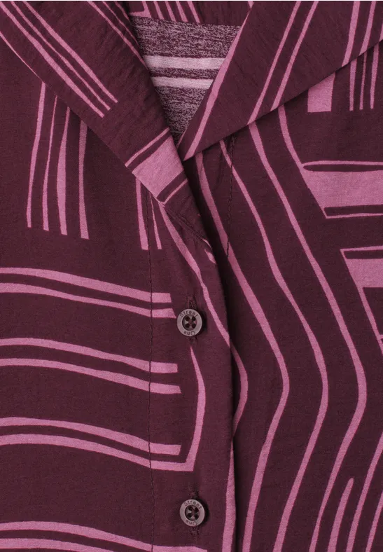 Nahaufnahme eines lila-gemusterten Blazers mit grafischen Linien und zwei sichtbaren Knöpfen.