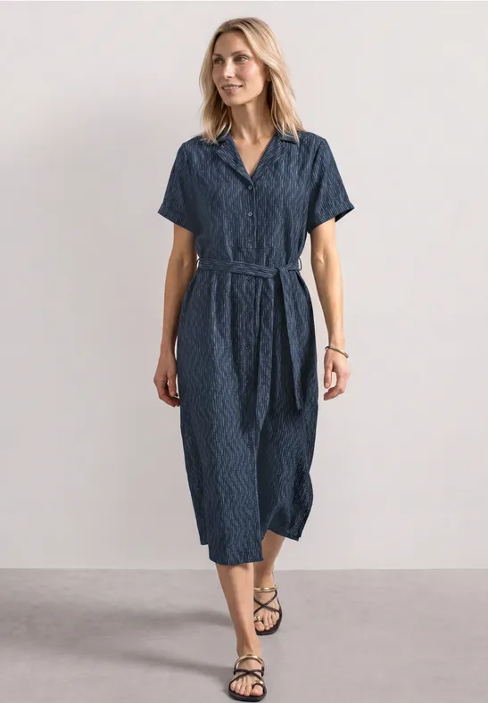 Femme portant une robe midi bleu marine cintrée, manches courtes, col V et ceinture sur fond sobre