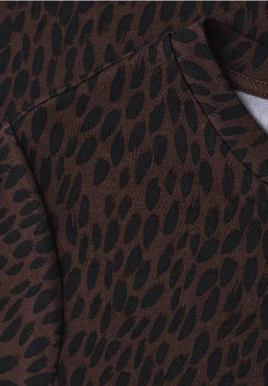 Bruine stof met onregelmatig zwart druppelpatroon, doet denken aan een trui of hoodie.