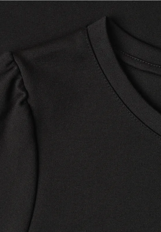Gros plan d’un haut noir à encolure ronde et couture d’épaule