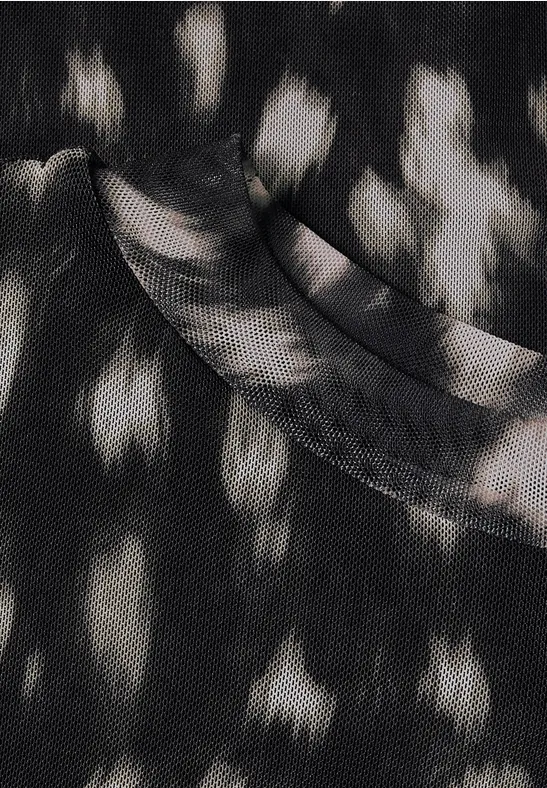 Schwarzes T-Shirt mit unregelmäßigen weißen Flecken, abstraktes Stoffmuster