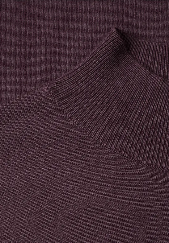 Nahaufnahme eines dunkelvioletten, gestrickten Rollkragenpullovers.