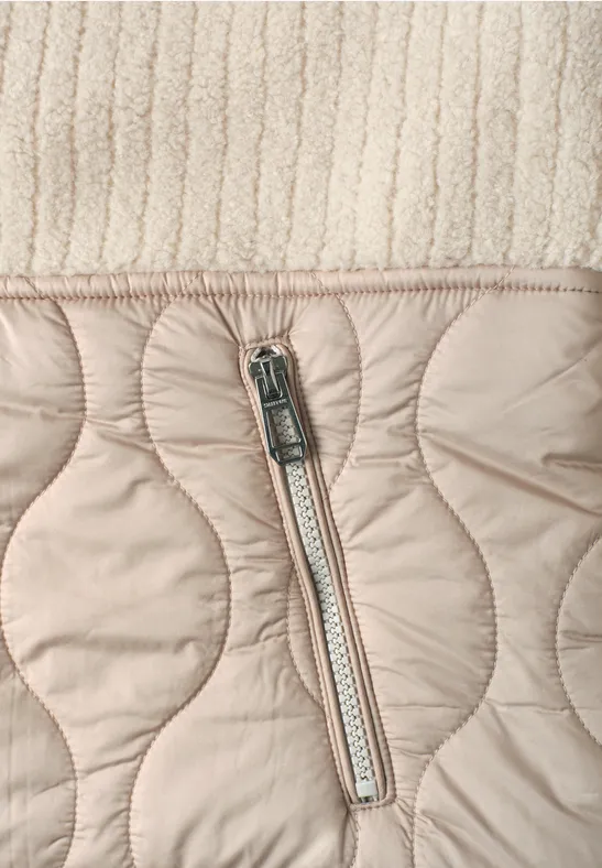 Beige gesteppte Jacke mit Reißverschlusstasche und Strickbund.