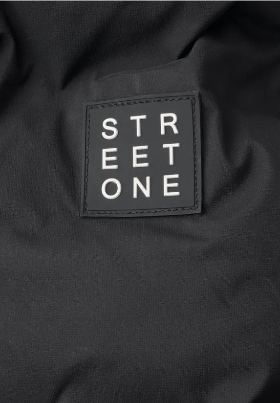 Nahaufnahme eines schwarzen Stoffes mit einem aufgenähten Patch mit der Aufschrift 'STREET ONE'.