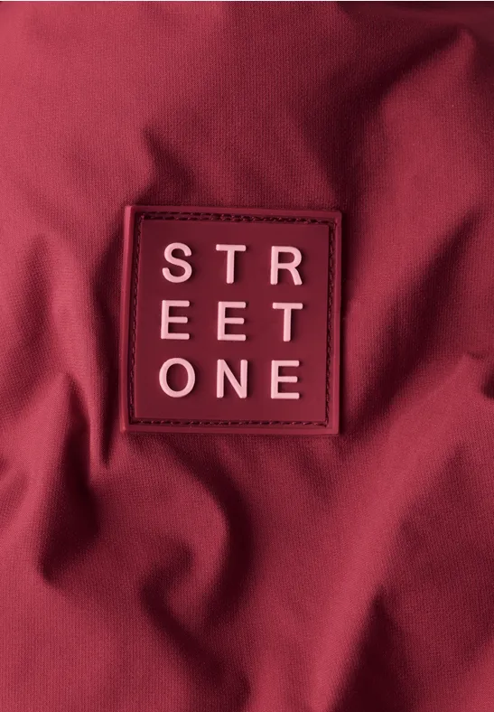 Dieprode stof met een opgenaaid label 'STREET ONE'.