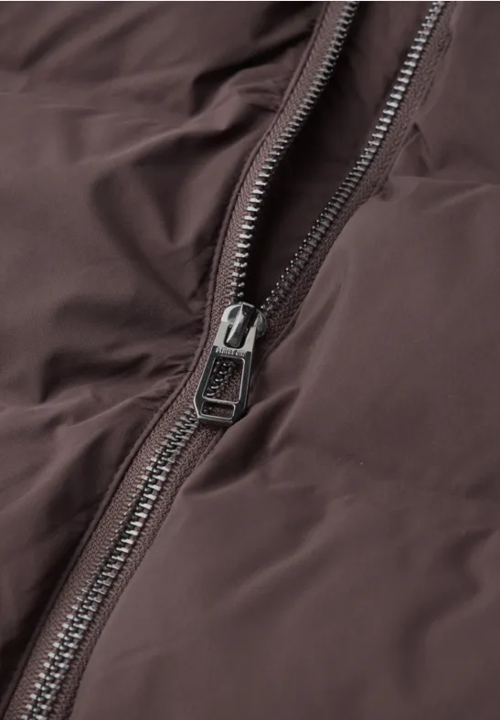 Gros plan d'une fermeture éclair sur une veste marron.