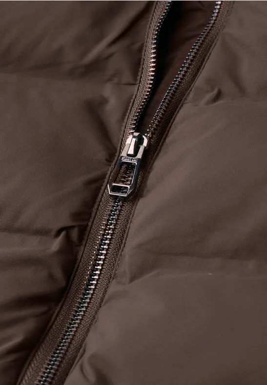 Gros plan d'un manteau matelassé marron avec une fermeture éclair métallique argentée.
