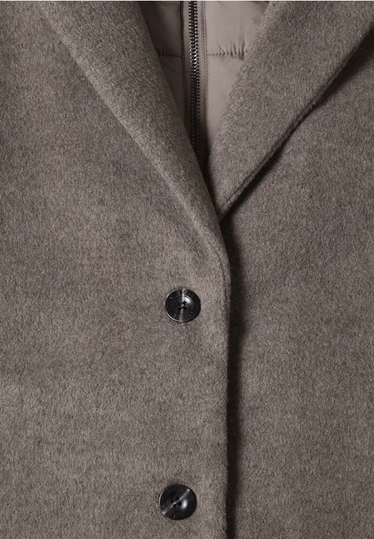 Gros plan d’un manteau gris en laine avec revers et deux boutons noirs