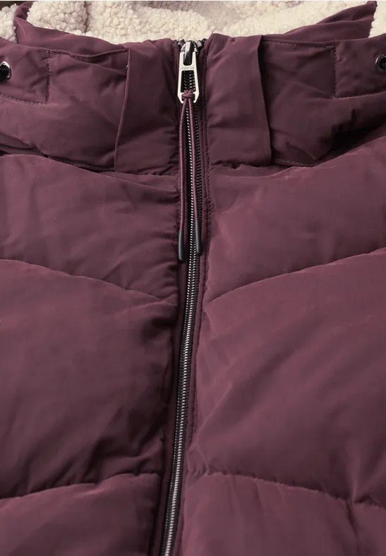 Nahaufnahme einer auberginefarbenen Daunenjacke mit mittigem Reißverschluss und weichem Fleecefutter.