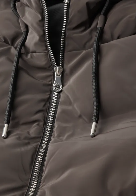 Nahaufnahme einer gesteppte Jacke mit Reißverschluss und Kapuzenkordeln in dunklem Grau.