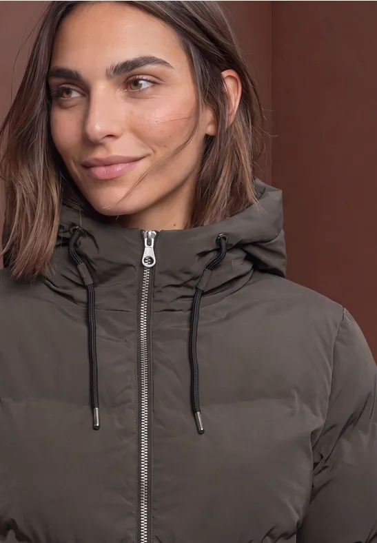 Nahaufnahme einer Frau in brauner Steppjacke mit Kapuze, Reißverschluss und Kordelzügen.