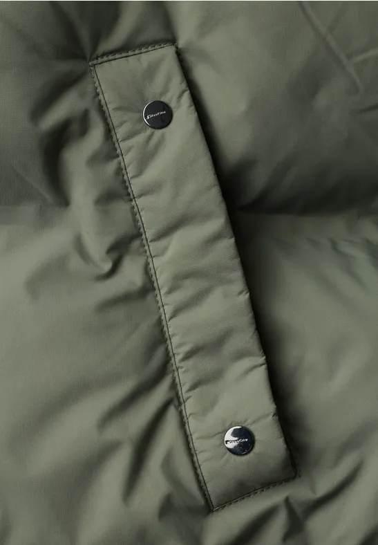 Nahaufnahme einer olivgrünen Steppjacke mit Druckknöpfen