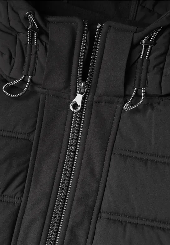Schwarz wattierte Jacke mit Reißverschluss und Zugschnüren, Nahaufnahme des Mittelteils.