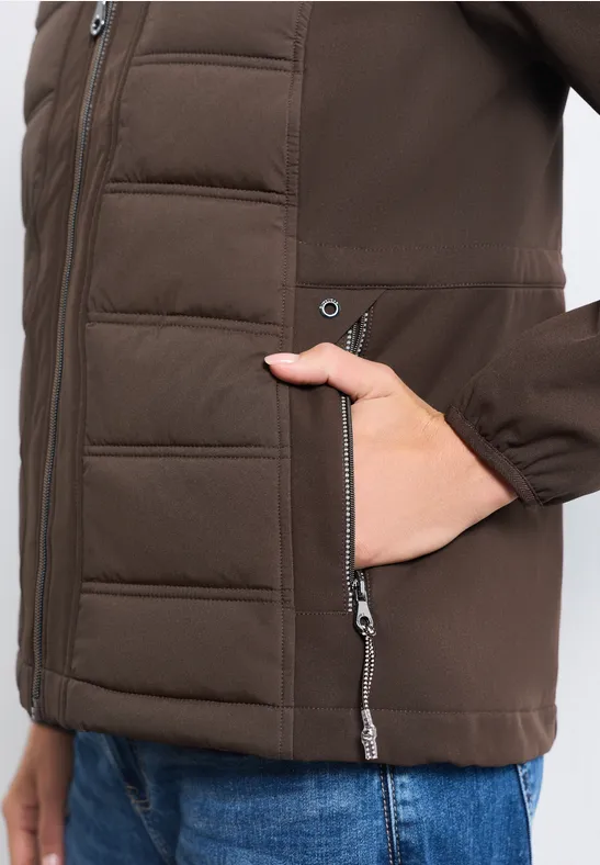 Eine Person trägt eine braune wattierte Jacke mit Reißverschlusstaschen