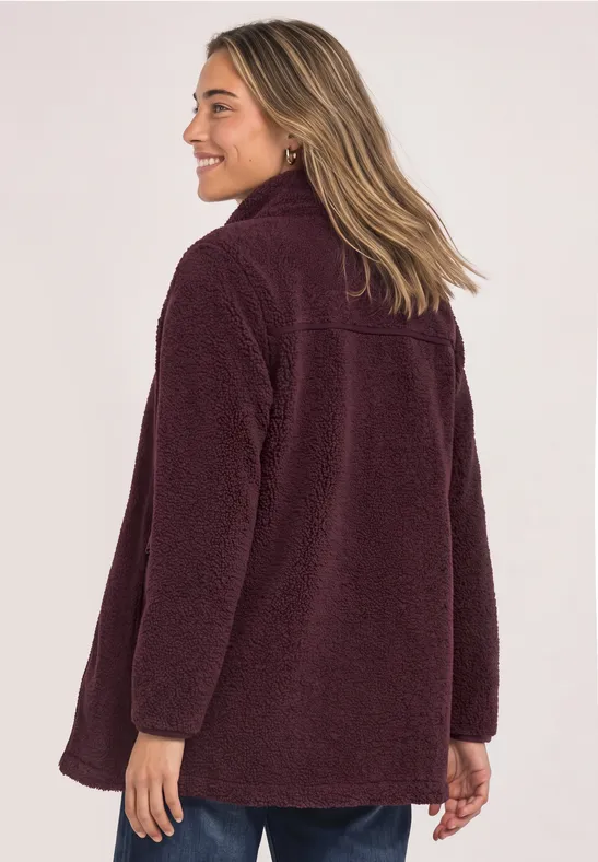 Femme aux cheveux mi-longs porte une veste en polaire teddy bordeaux vue de dos.
