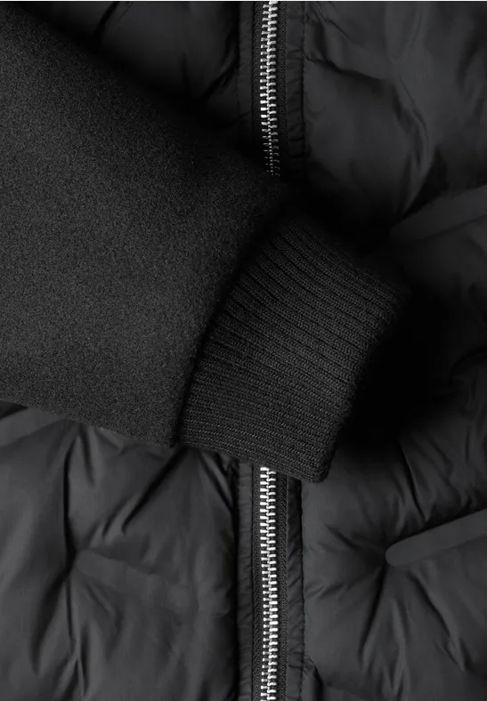 Schwarze, gesteppte Jacke mit Reißverschluss und elastischem Rippbündchen am Ärmel.