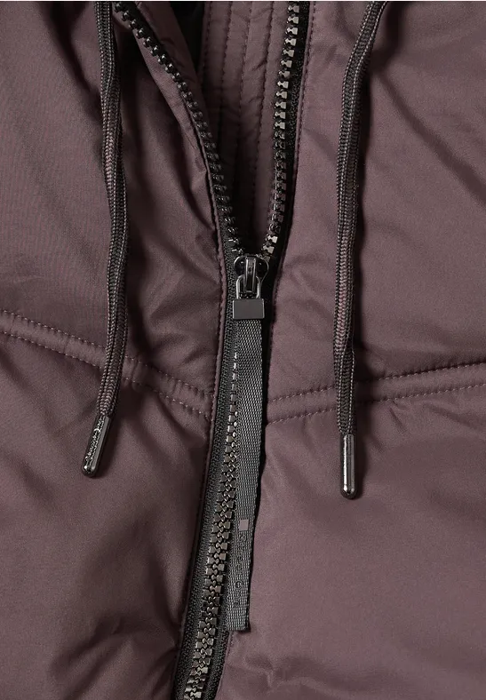 Nahaufnahme einer braunen Jacke mit Reißverschluss und Kordelzug.
