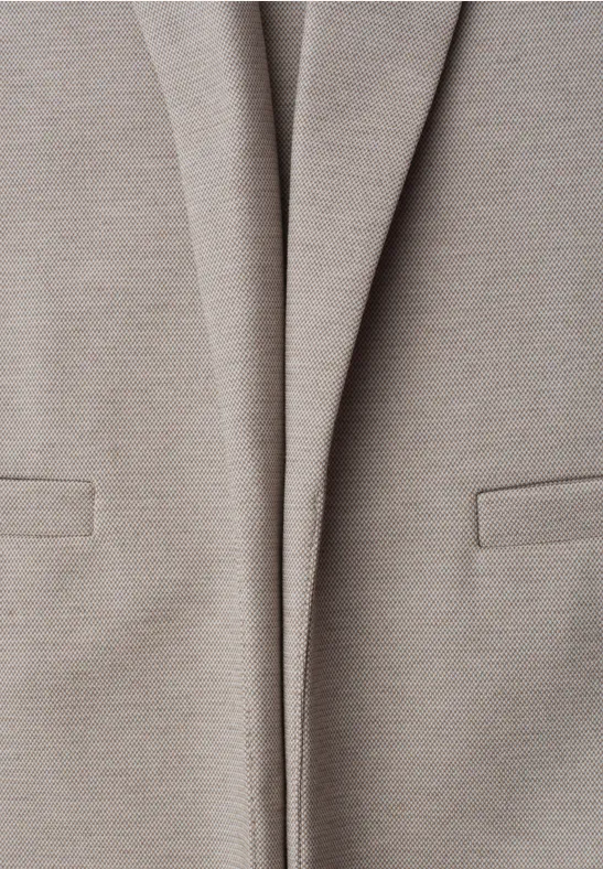 Gros plan sur une veste blazer beige clair avec poches sur le devant