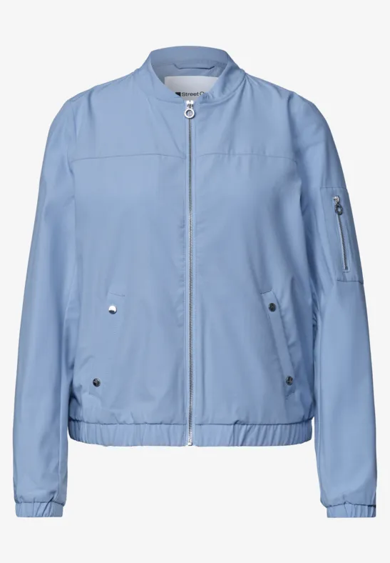 Lichtblauwe bomberjas van licht materiaal, rits voor, geribde boorden en zakken.