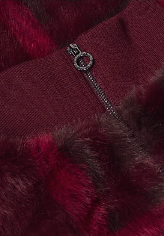 Nahaufnahme einer bordeauxroten Pelzjacke mit Reißverschluss