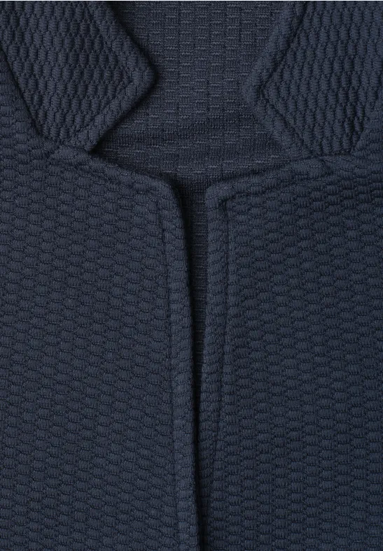 Gros plan sur un tissu rembourré sombre à motif alvéolaire.
