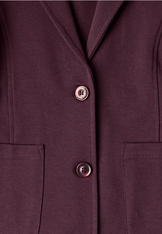 Donkerpaarse blazer met twee knopen en opgestikte zakken tegen witte achtergrond.