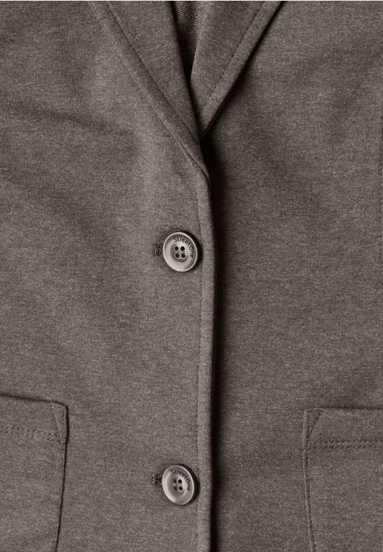 Nahaufnahme eines graubraunen Blazers mit zwei Knöpfen und seitlichen Taschen.