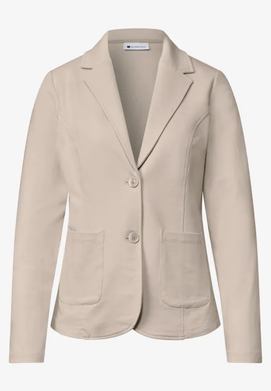 Beiger Damenblazer mit Reverskragen, zwei Knöpfen und aufgesetzten Taschen.