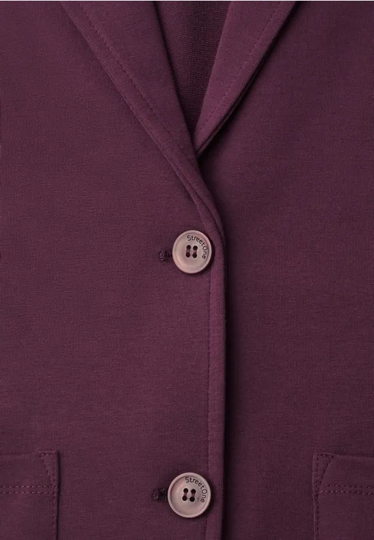 Nahaufnahme eines dunkelvioletten Blazers mit Knöpfen und Taschen.