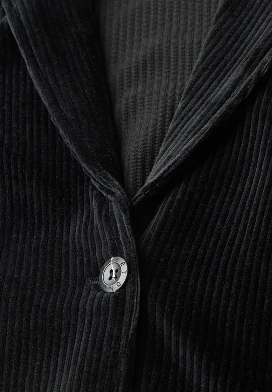 Nahaufnahme eines schwarzen Cord-Blazers mit Knopf und Revers, feine vertikale Struktur sichtbar.