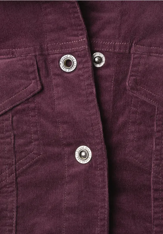 Lila Cordjacke mit silbernen Druckknöpfen und aufgesetzten Taschen im Detail.